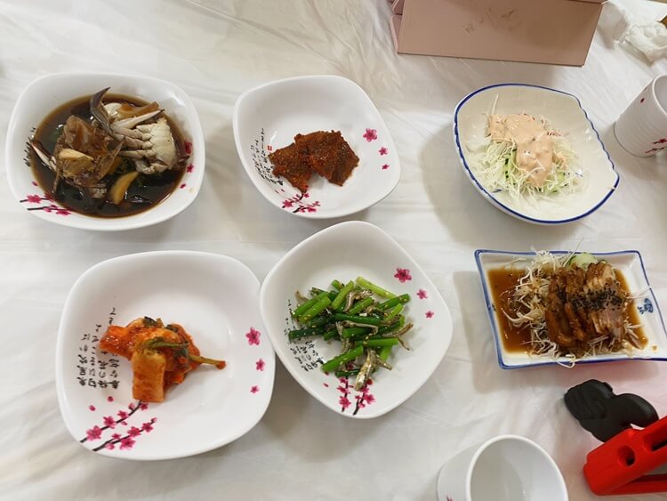 생생횟집에서 나오는 반찬으로 간장게장, 가자미조림, 샐러드, 김치, 멸치볶음, 냉채 족발이다.