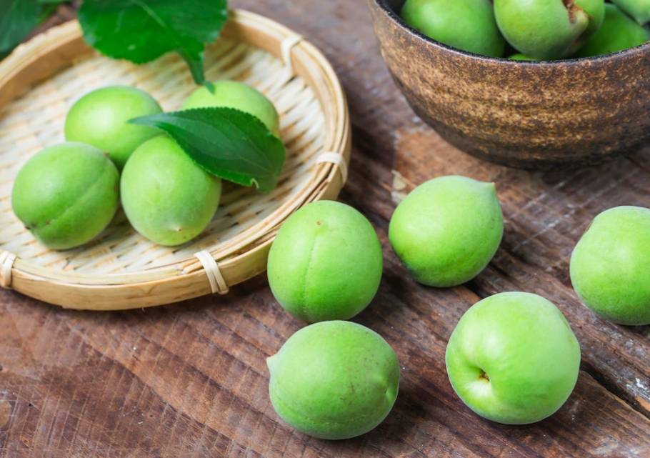 바구니에 담겨 있는 매실과 테이블 위에 올려있는 매실 5개