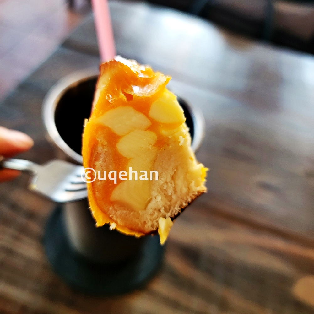 카페 럿지 베이커리 치즈단지를 잘라 포크롤 집어 들고 있다.