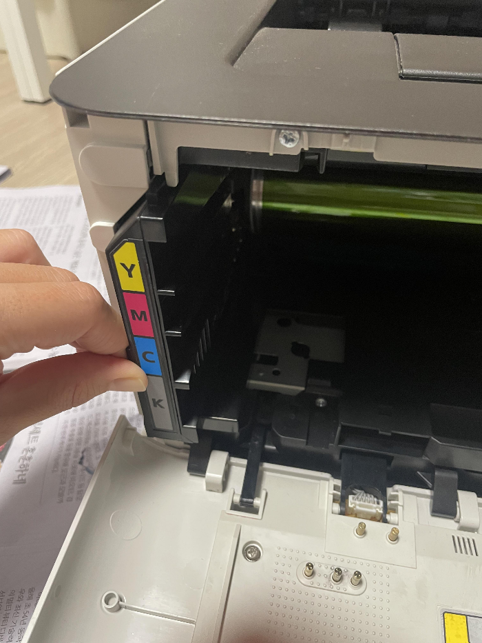 삼성 프린터 폐토너통을 손으로 밀어넣어 장착하는 모습