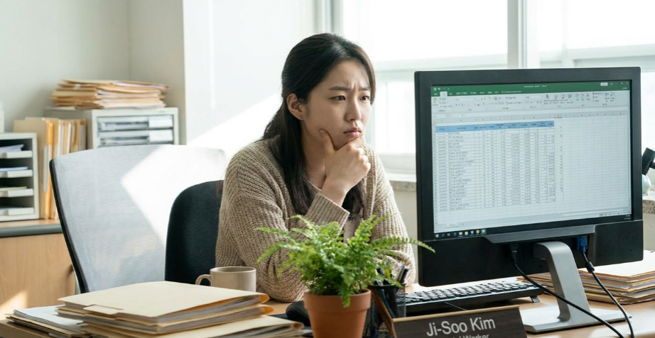 모니터 앞에서 머리를 감싸 쥐고 고민하는 신입 사회복지사
