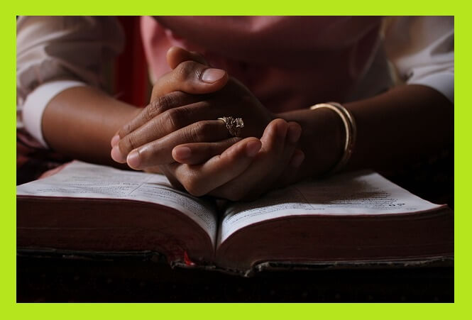 펼친-성경-위-기도하는-손