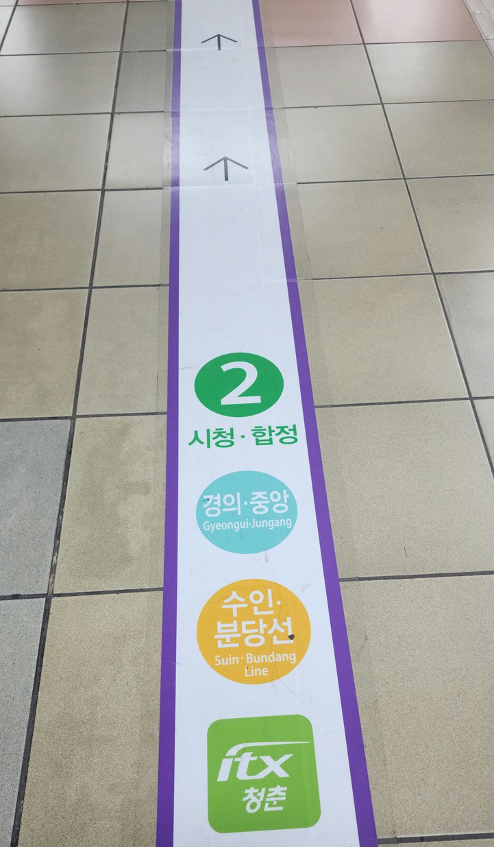 지하철 바닥에 그려진 보라색 화살표와 노선 표식.
길을 따라가지만 스스로의 방향을 잃은 현대인의 모습을 상징한다.