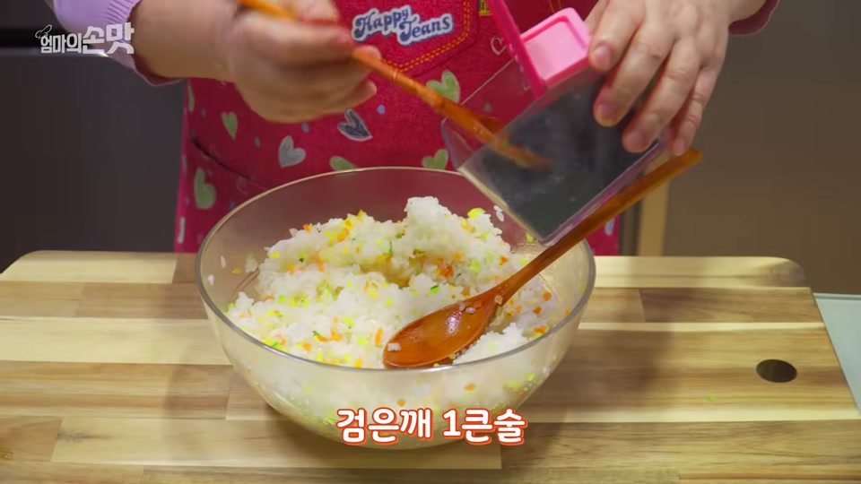 밥에 볶은 채소와 검은깨를 넣는 장면