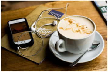 A phone and an earpiece and a coffee