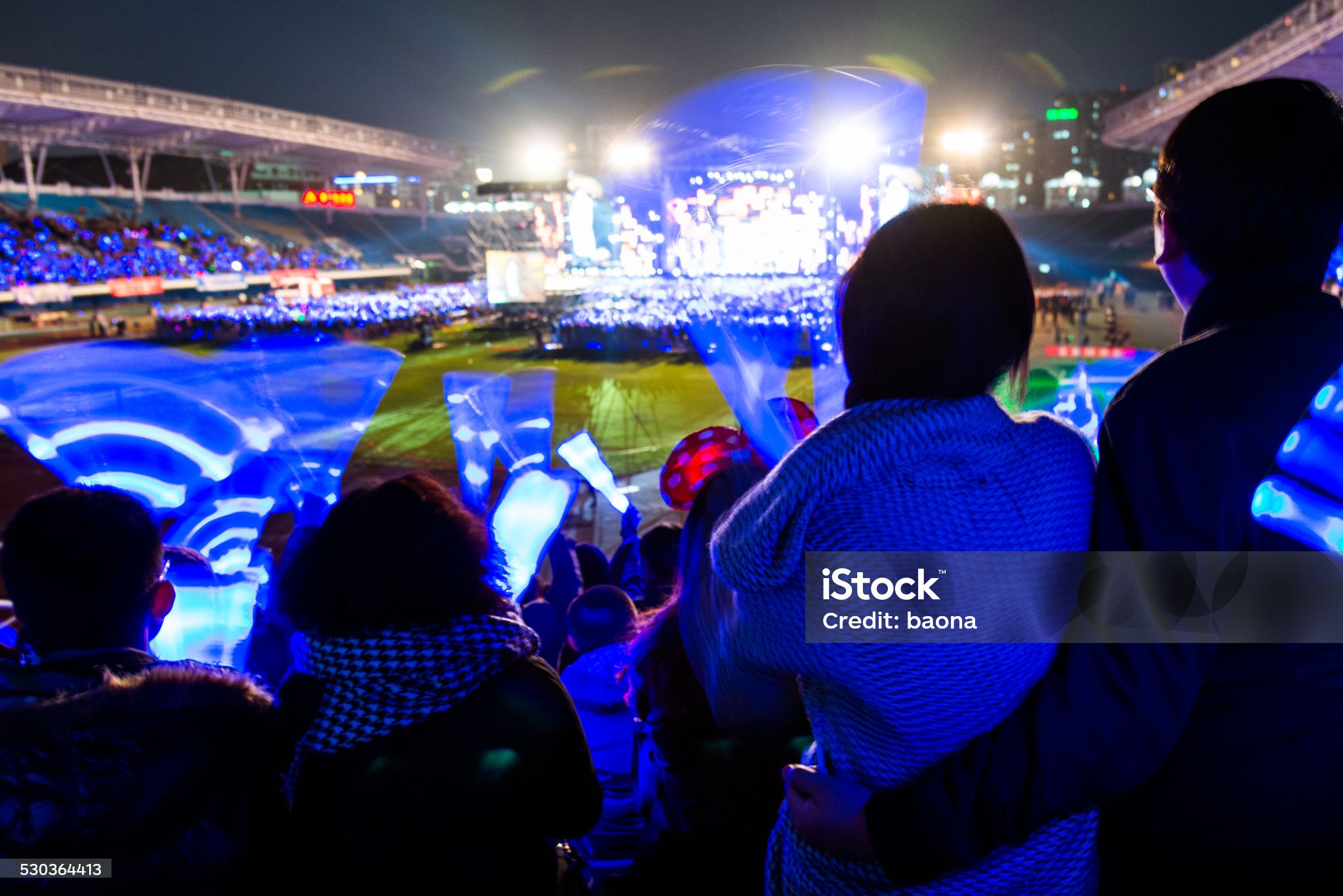 수많은 사람들이 모여서 파란봉을 흔들면서 멀리 부대에서 공연하는 축제를 감상하고 즐기는 모습입니다.