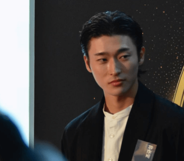 조규성 선수가 검은 자켓을 입고 어딘가 응시하는 장면