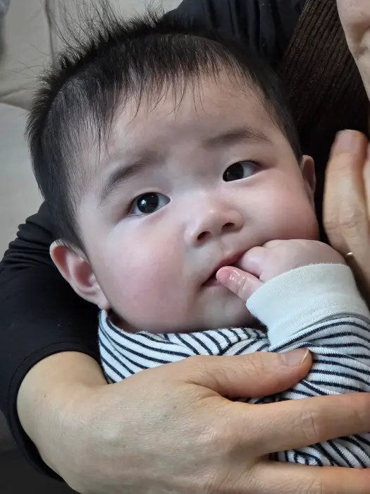 아기가 손을 입에 넣는 모습