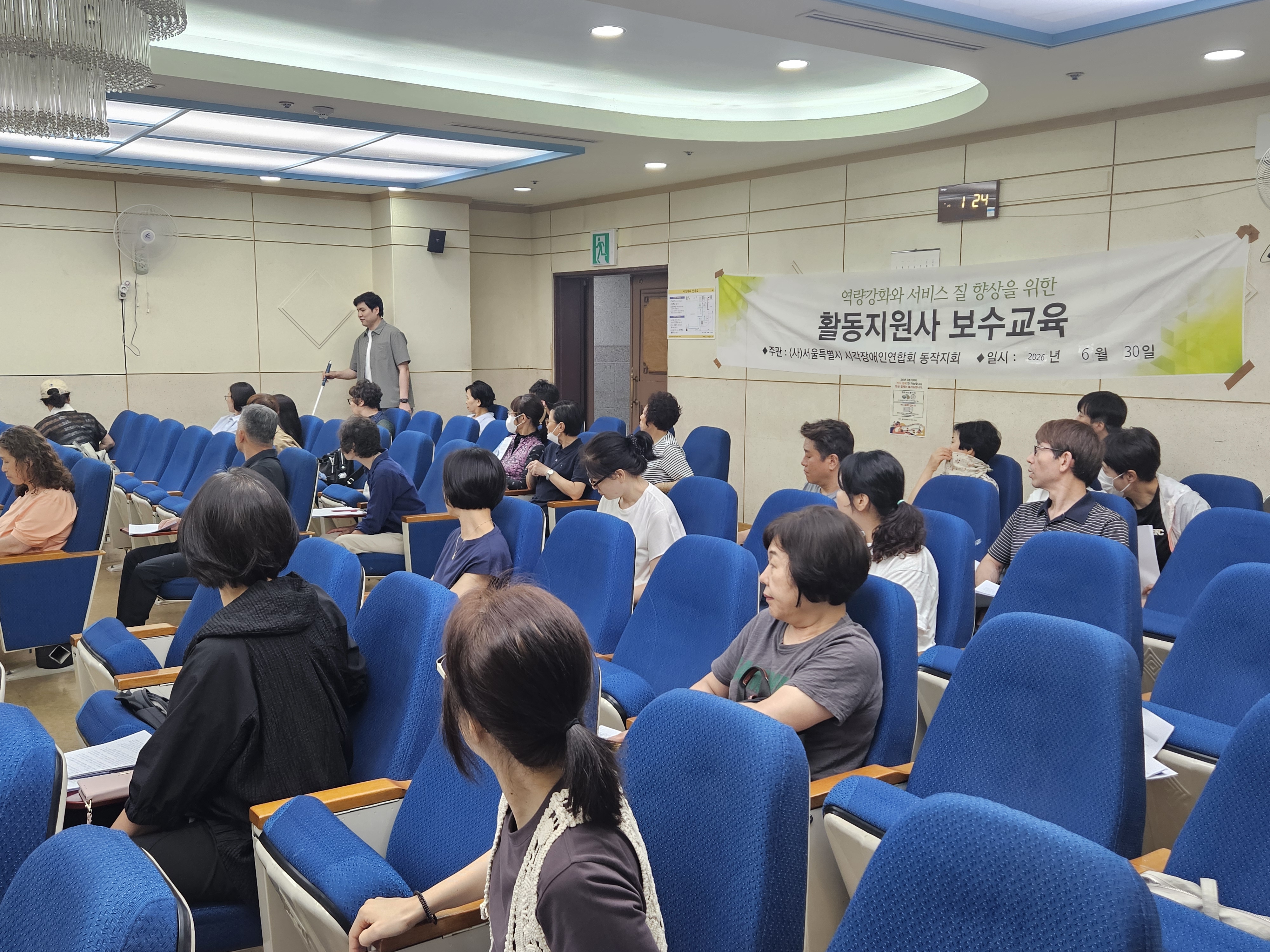 시각장애인 강사가 흰지팡이를 활용하여 활동지원사들에게 장애인식개선교육을 진행하고 있는 모습