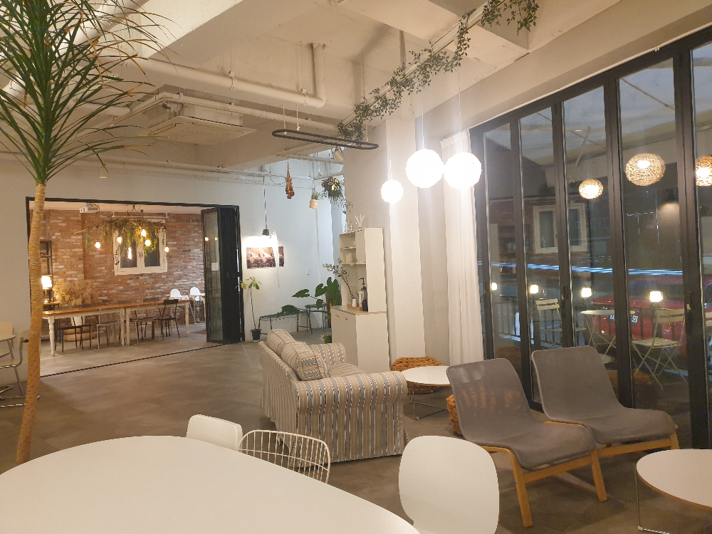 넓은 내부. 흰색 벽면과 그레이 바닥 그리고 뒤쪽 별도 공간이 보인다.