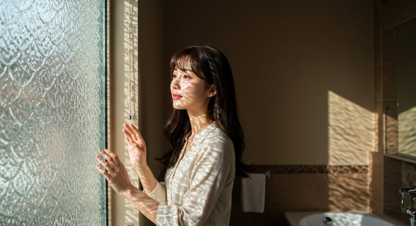 모루유리를 통과하는 햇살을 맞고 있는 여성