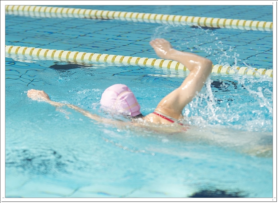 실내 수영장에서 수영을 하고 있는 여성의 뒷모습