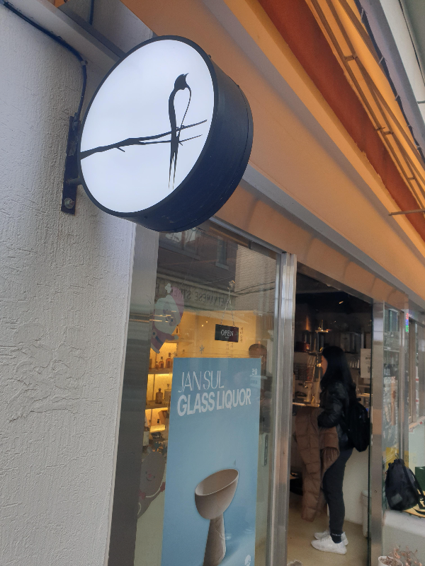 제비가 앉아 있는 그림이 있는 작은 돌출간판