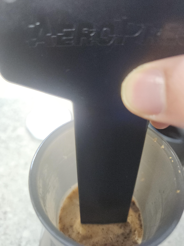 스틱으로 가볍게 커피 위쪽을 젓는 모습