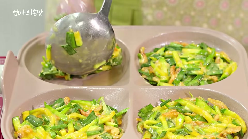 팬에 반죽을 떠서 올리는 장면