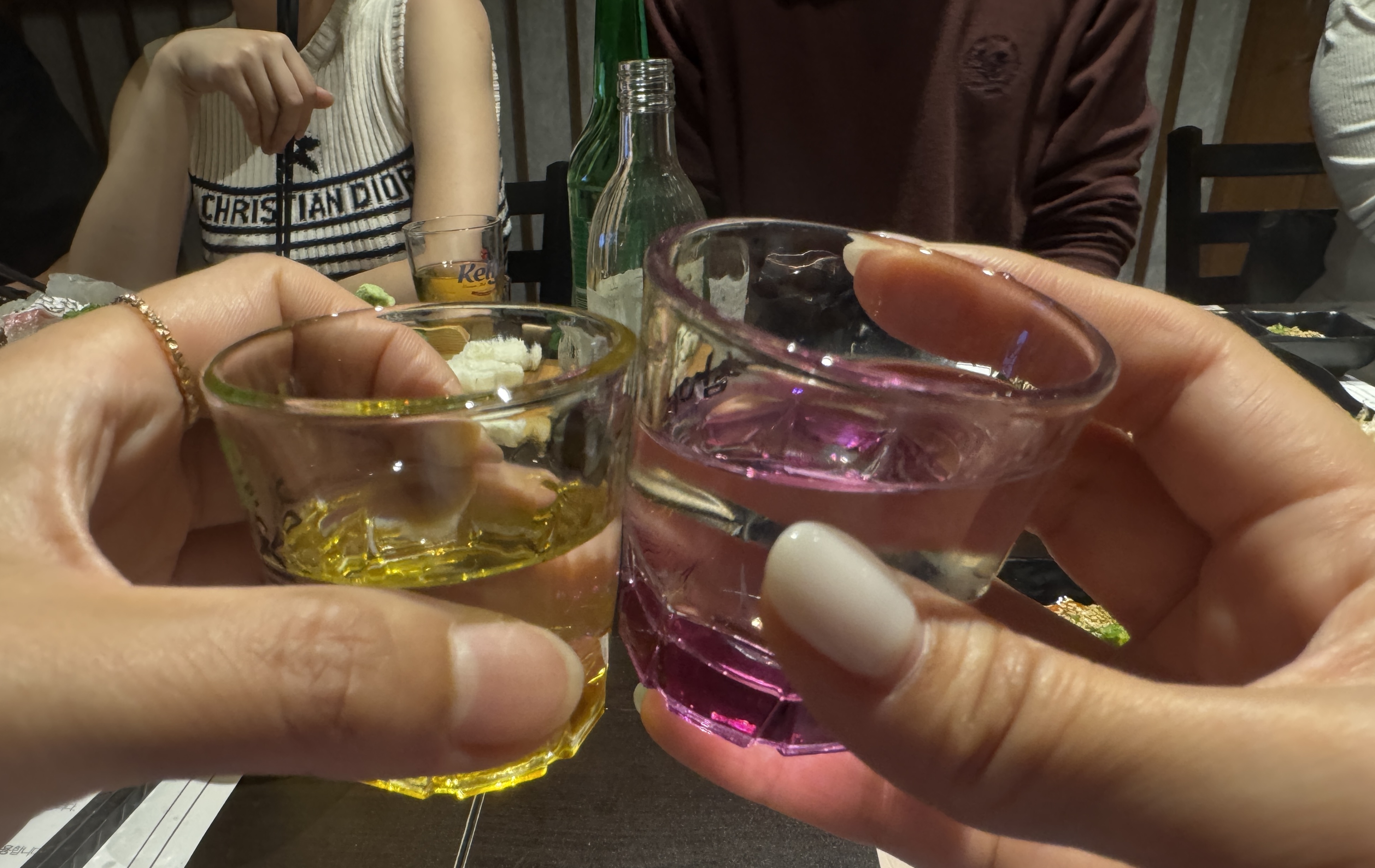 친구와 마주 앉아 샷잔을 부딪히는 순간. 잔 속 분홍빛과 노란빛이 분위기를 물들인다.