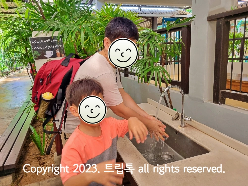 두 사람이 개수대레서 손을 씻고 있다