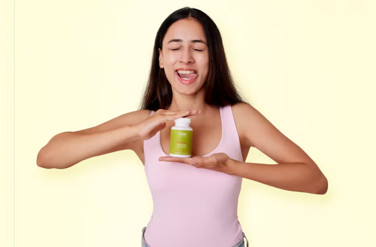 밝은 배경 앞에서 장 건강 보조제를 들고 웃는 여성