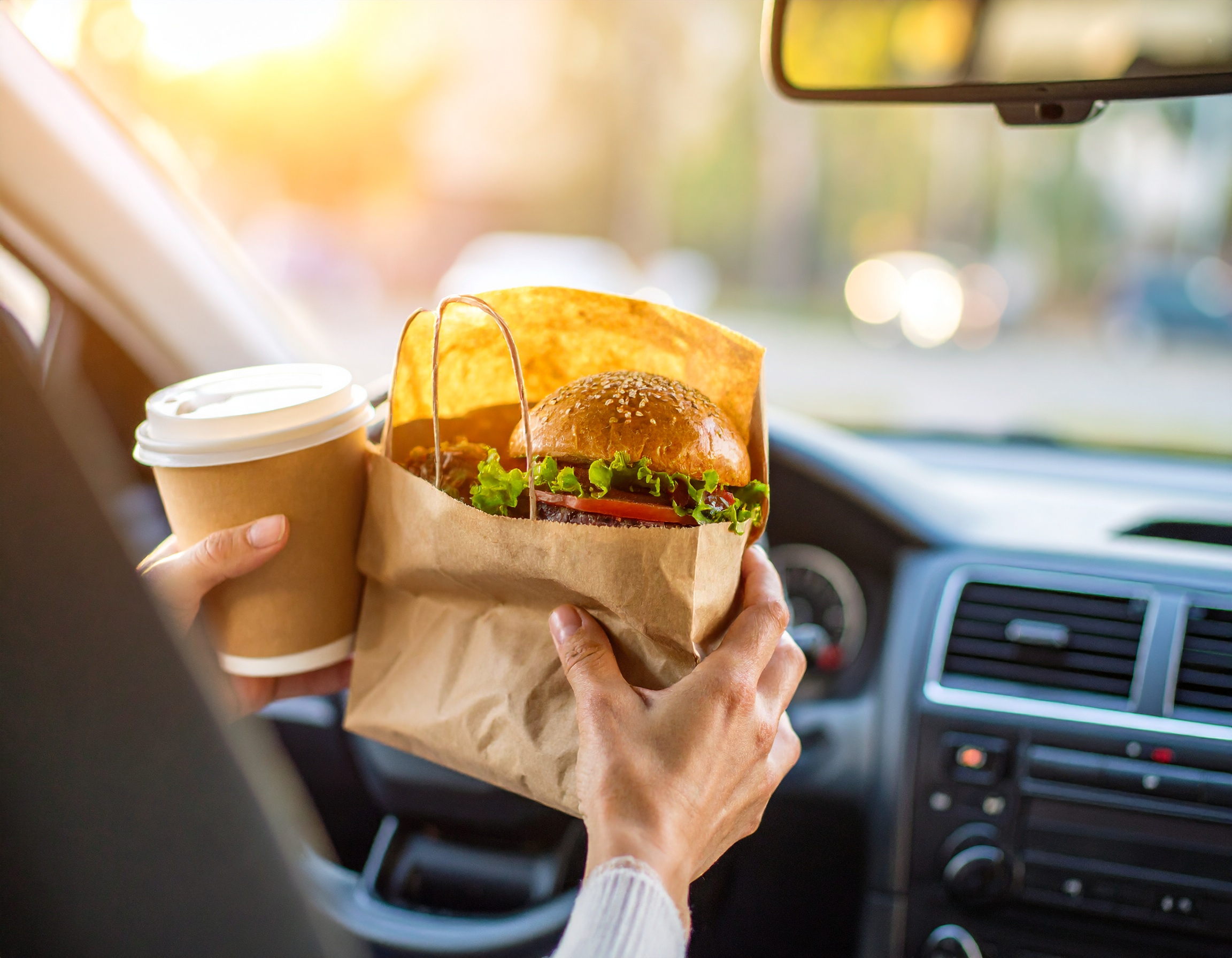 차 안에서 햄버거와 커피를 받는 모습