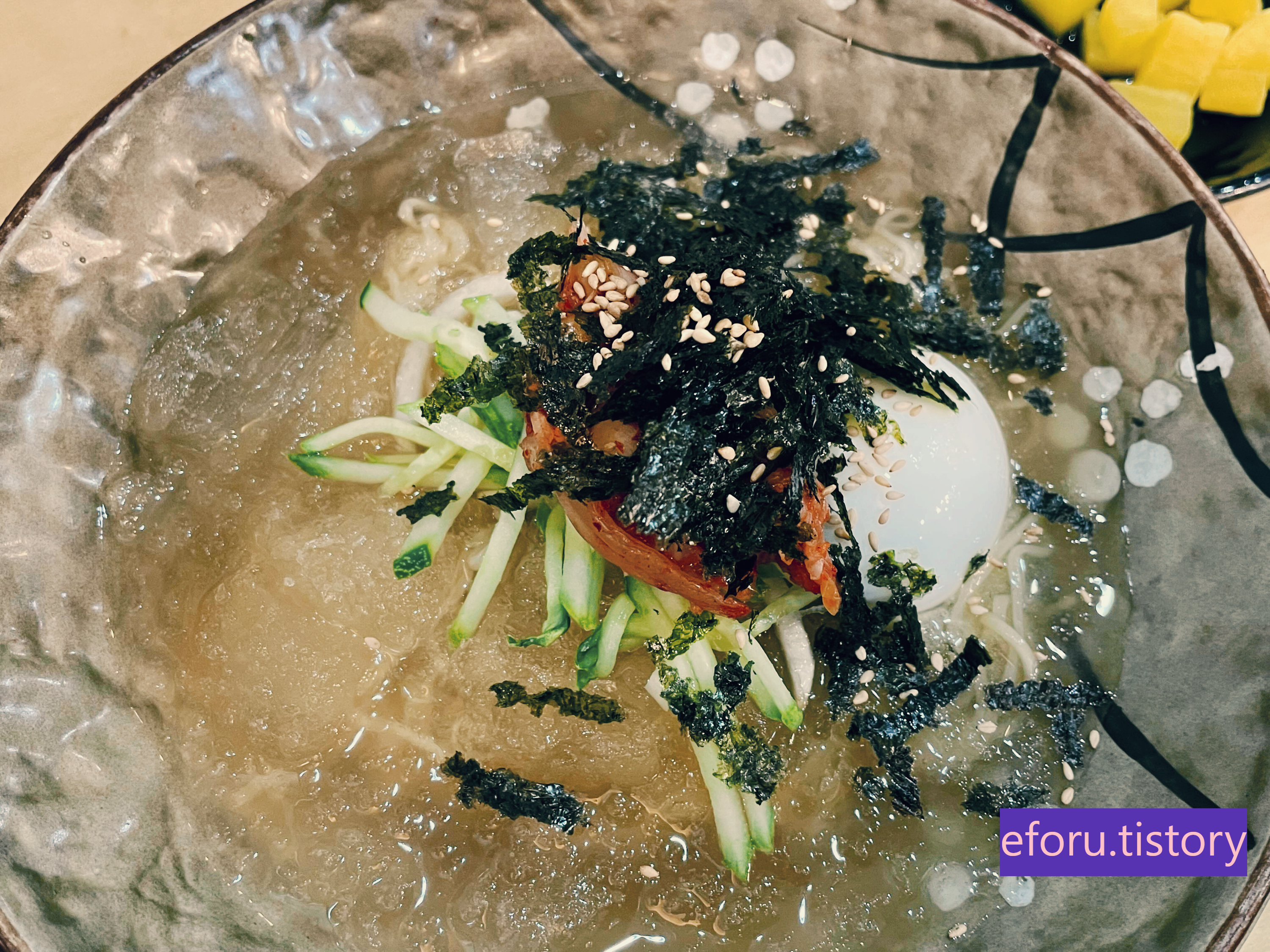 김가루와 깨 그리고 오이채 등이 올려진 물냉면