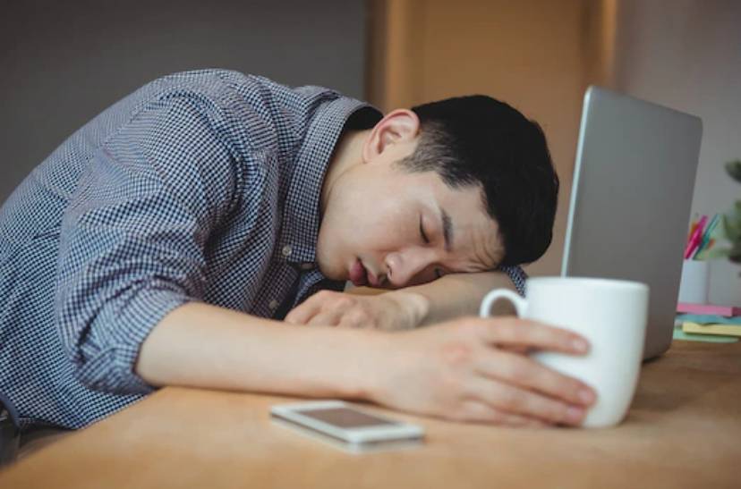 노트북 앞에 엎드려서 자고 있는 짧은머리 남성