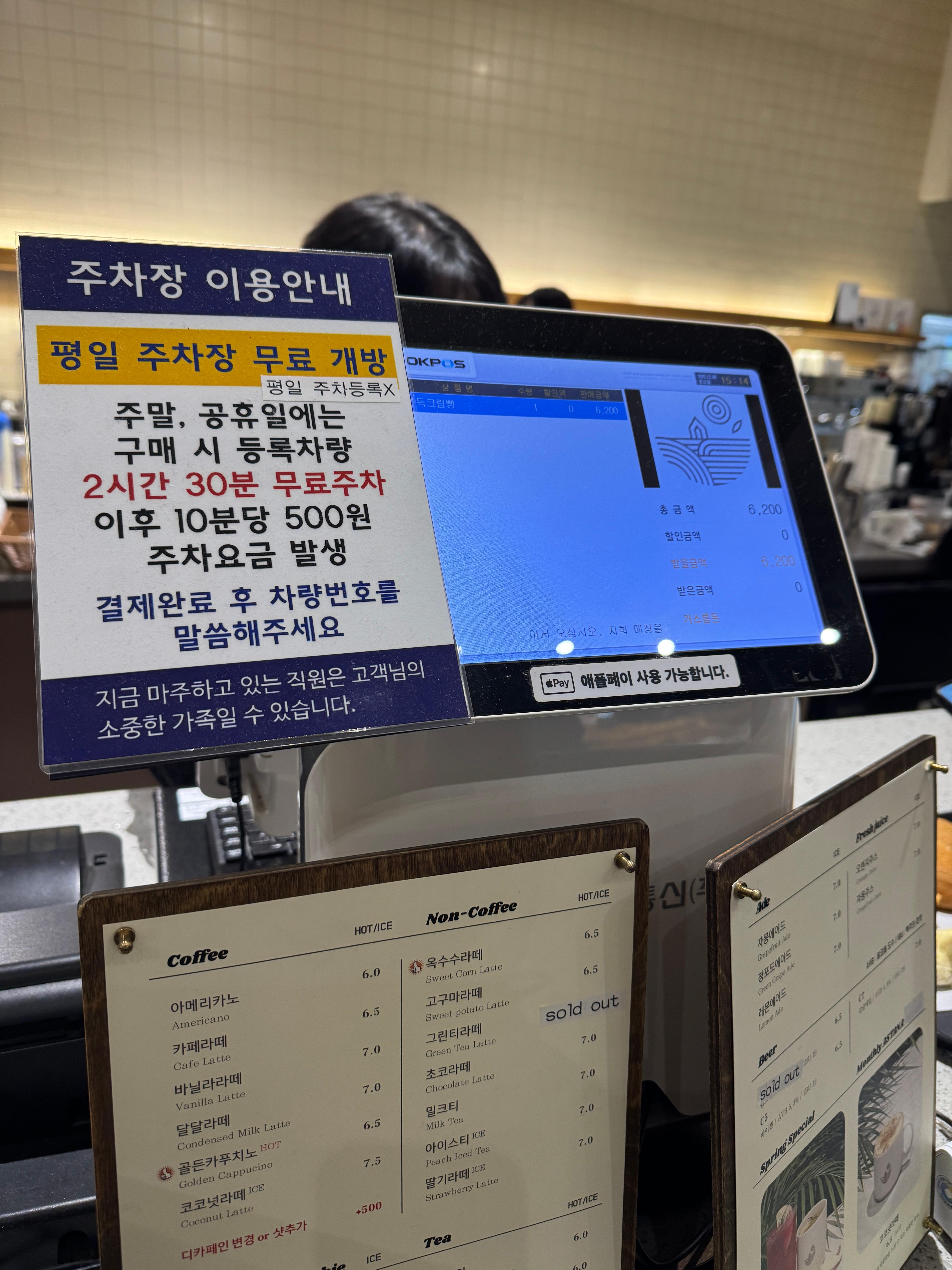 동탄 카페 아스타나 주차장 이용 안내, 주말&middot;공휴일 구매 시 2시간 30분 무료 주차 및 이후 요금 안내가 적힌 계산대 주차 안내문