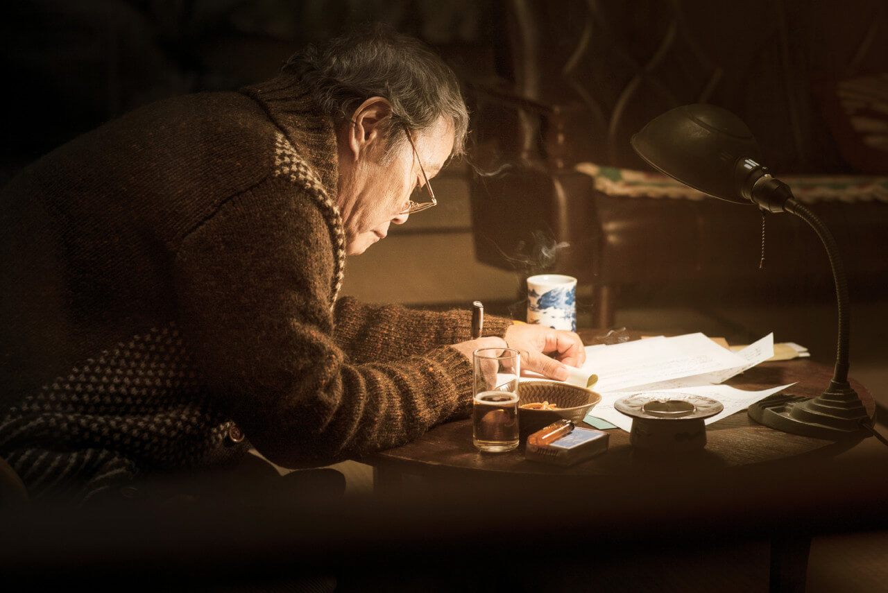 나미야 잡화점의 주인인 나미야 할아버지가 편지를 쓰고 있는 모습