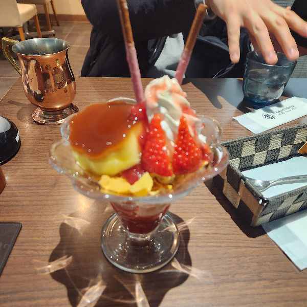 딸기와 아이스크림 그리고 푸딩이 올려져 있는 파르페와 금속 잔에 담긴 더치 커피