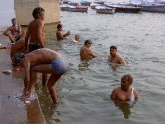 갠지즈강에-신의-은총을-받기위해-들어가-몸을-씻고있는-여러명의-남성들