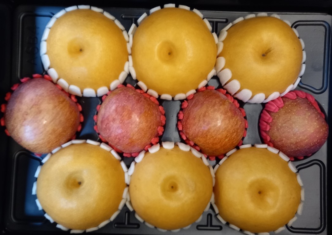 검은 받침에 배 6개와 사과 4개가 담긴 추석 과일 선물세트