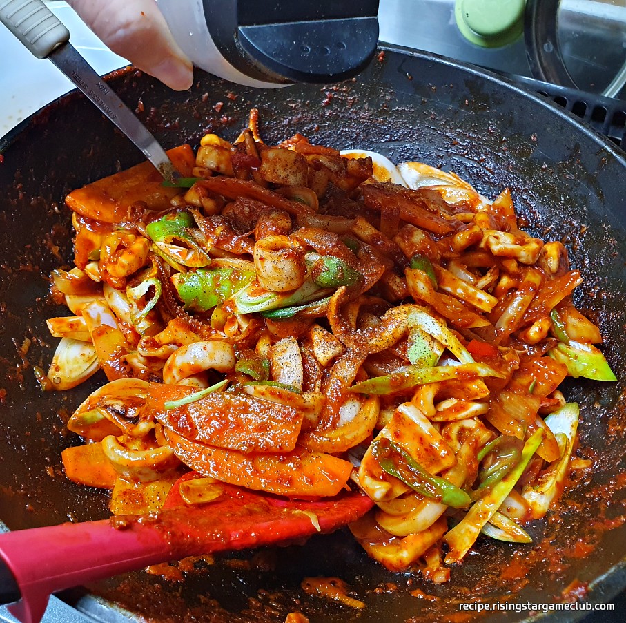 맛있는 오징어볶음에 후추를 뿌리는 사진