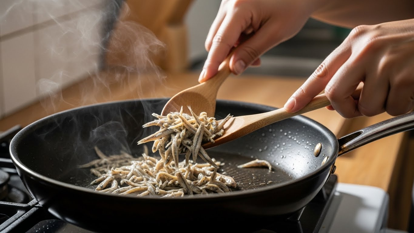 팬에서 잔멸치를 볶아 비린내를 제거하는 과정