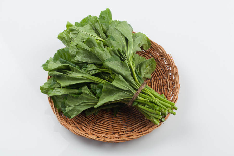 야생에서 채취를 한 아우의 잎을 잘 세척해서 건조한 후&#44; 하얀 바닥 위에 동그란 대나무 그릇 위에 아욱 한다발을 끈으로 묶어서 올려놓고 위에서 찍은 사진