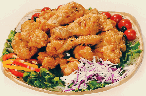 큰 접시에 간장치킨이 가득 있다. 노릇노릇 튀긴 치킨과 주변에는 상추, 양배추채, 파프리카채들이 있다.