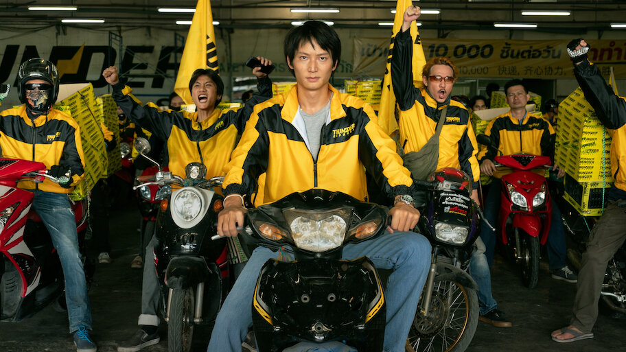 배달 오토바이를 타고 있는 남성들과 단체로 모인 노란색 유니폼 팀, 영화 매드 유니콘 스틸컷