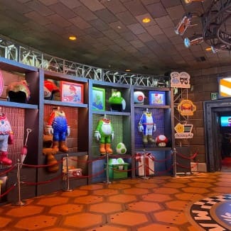 마리오 게임의 캐릭터 옷들이 정리되어 벽에 걸려있다.