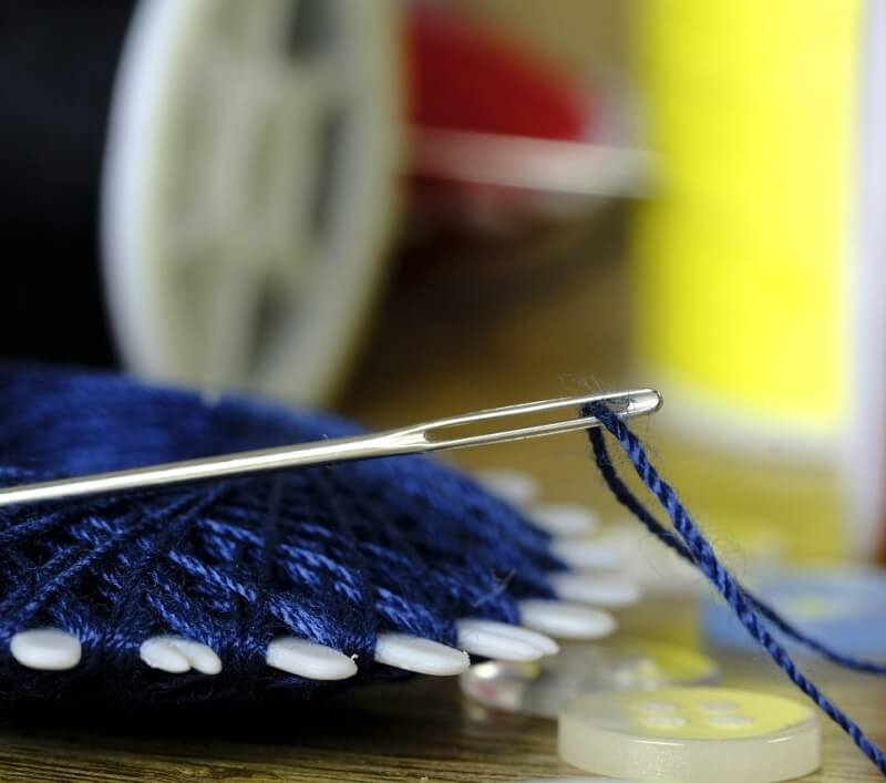 파란 실에 꽂혀 있는 바늘 사진