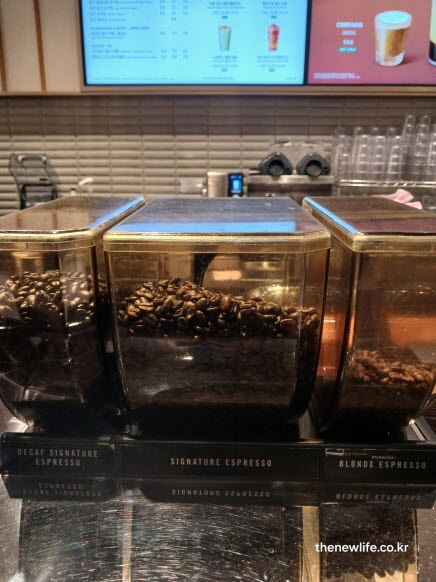 카페 바에서 원두가 담긴 통 세 개, 블랙커피의 향과 깊은 풍미를 상징