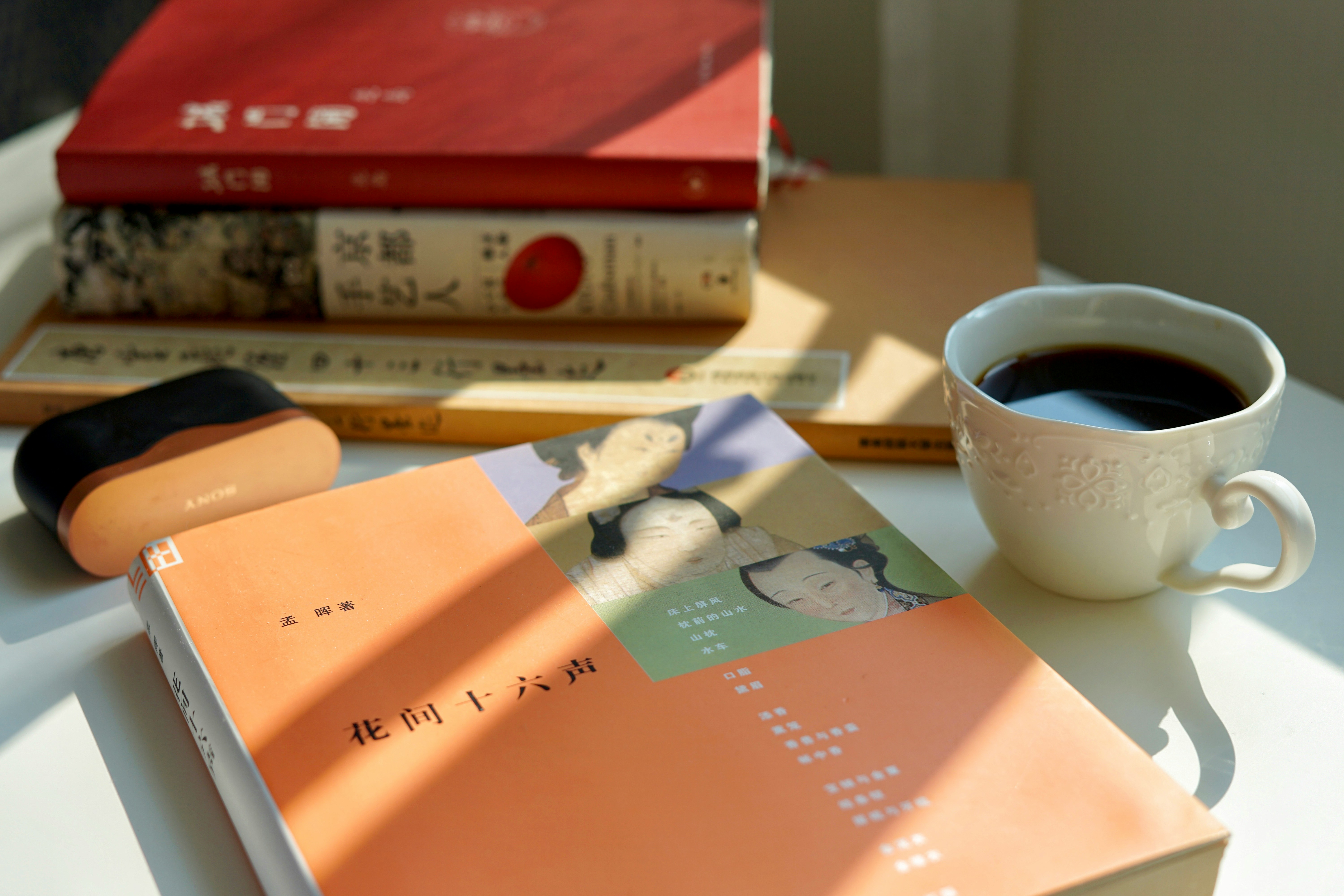 차 한 잔과 책이 놓인 책상 관련 사진