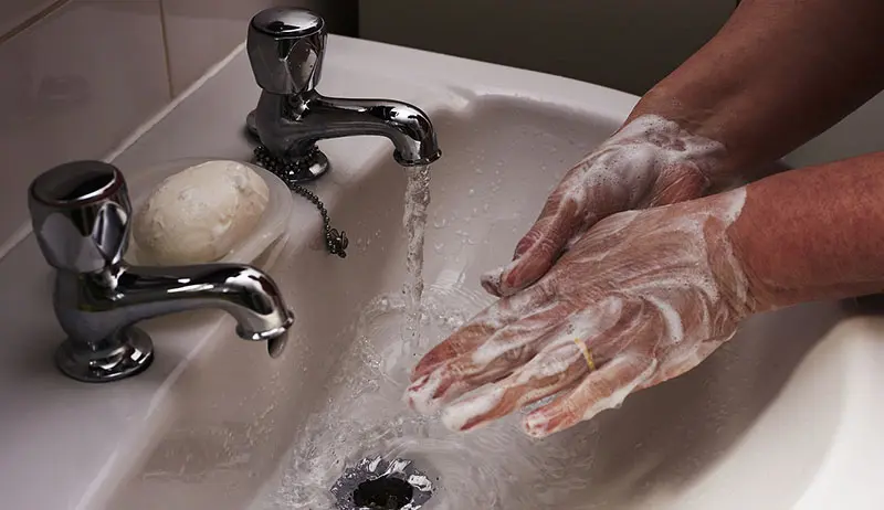 욕실에서 비누로 손 씻는 이미지.