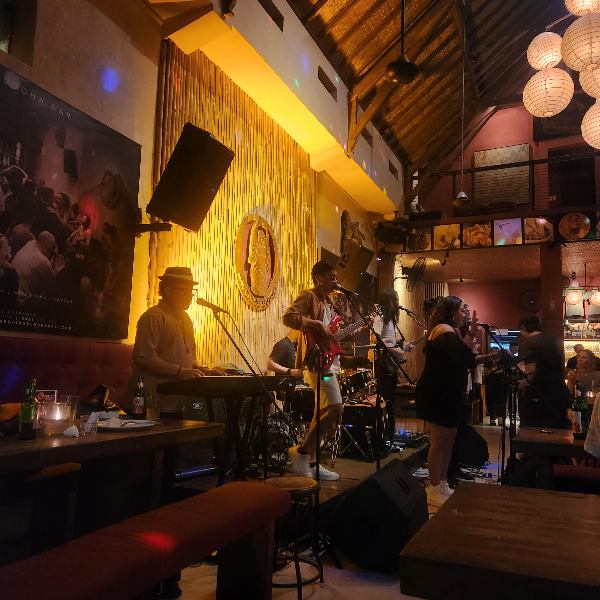 어두운 조명, 뒷쪽 Laughing Buddha Bar 마크, 밴드가 노래하고 있다.