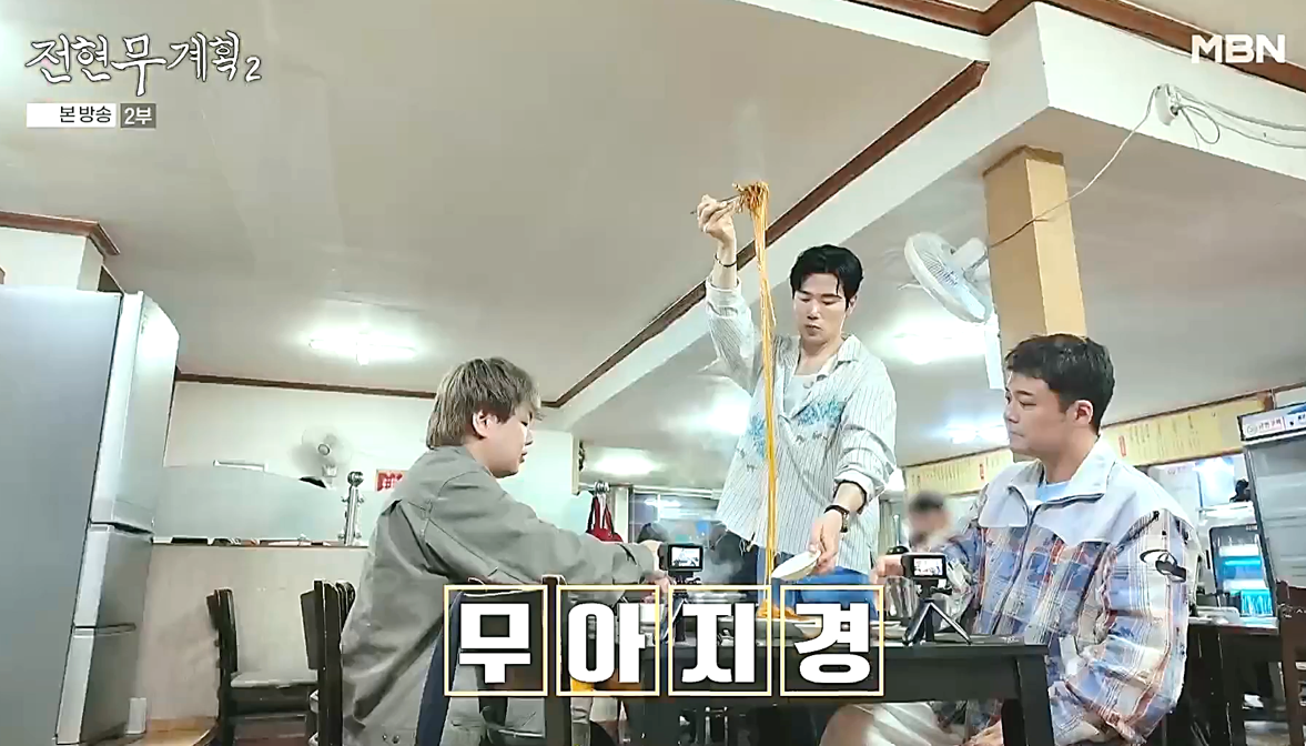 대구 덕성반점에서 배우 김강우가 면을 길다랗게 들어 올리는 모습, 전현무계획2 방송 장면