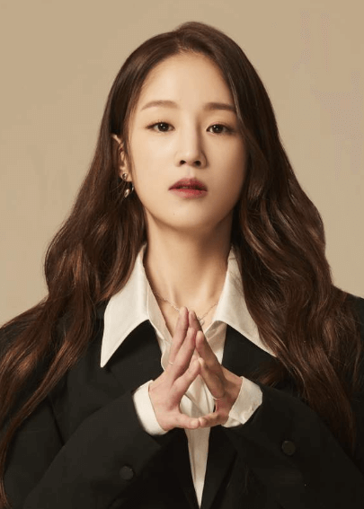 박보람이-하얀-블라우스와-검은색-외투를-입고-두-손을-모은-채-정면을-응시하고-있는-사진