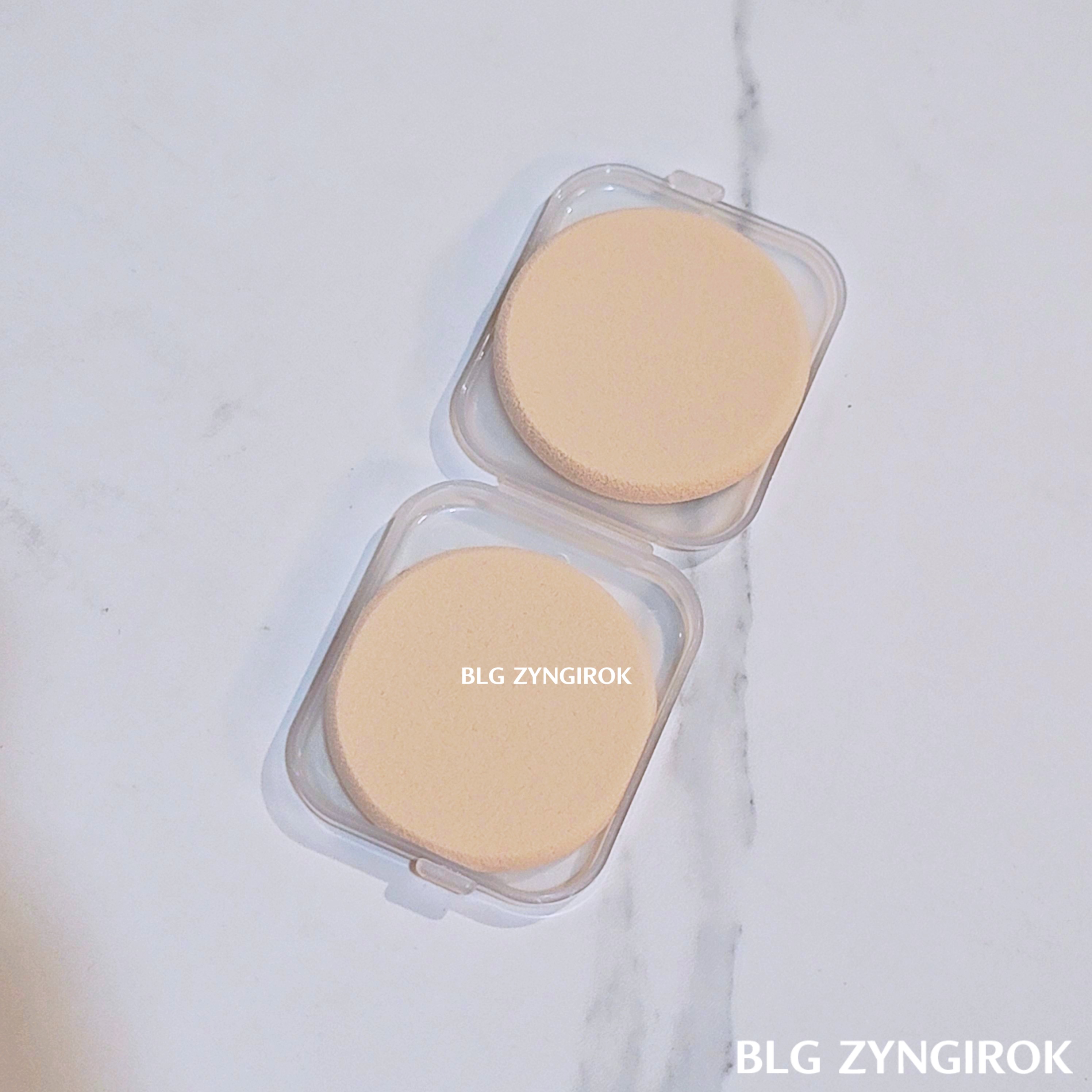 다이소 퍼프와 케이스 포장지를 뜯은 본품이 테이블 위에 놓여있다.