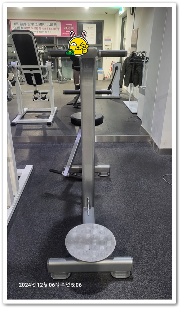 헬스장의 운동기구와 옷걸이가 놓여있는 모습.