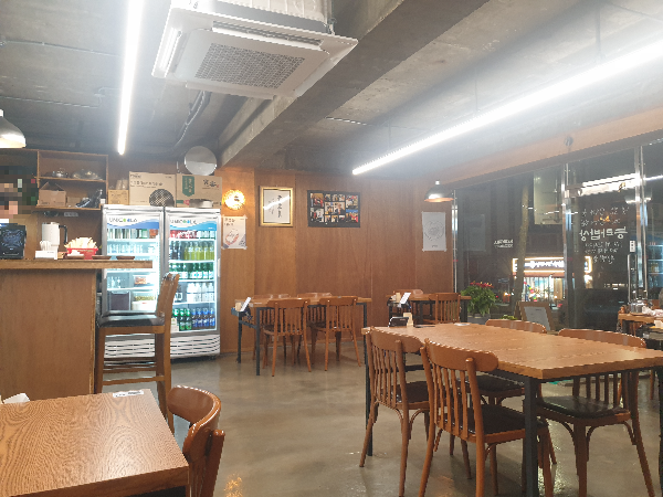 노출 콘크리트 바닥과 천장 그리고 우드 테이블과 벽체로 이뤄진 인테리어