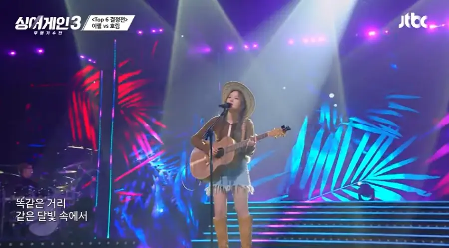 싱어게인3-
카우보이 모자를 쓰고 양갈래 머리를 딴채 갈색 긴팔티에 청미니스커트 갈색 롱부츠를 신고 갈색 통기타를 치며 스탠딩 마이크 앞에서 웃으며 노래하는 66호