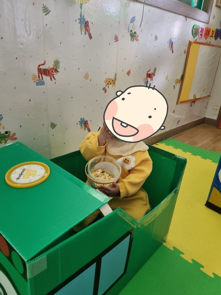 팝콘을 먹으며 영화를 기다리는 아이