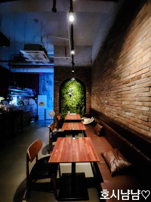 벽돌과 초록 식물 장식이 어우러진 감각적인 다이닝 공간