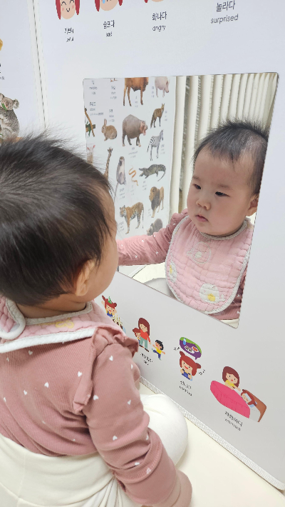 아기가 병풍 거울을 보고 있는 일상 사진